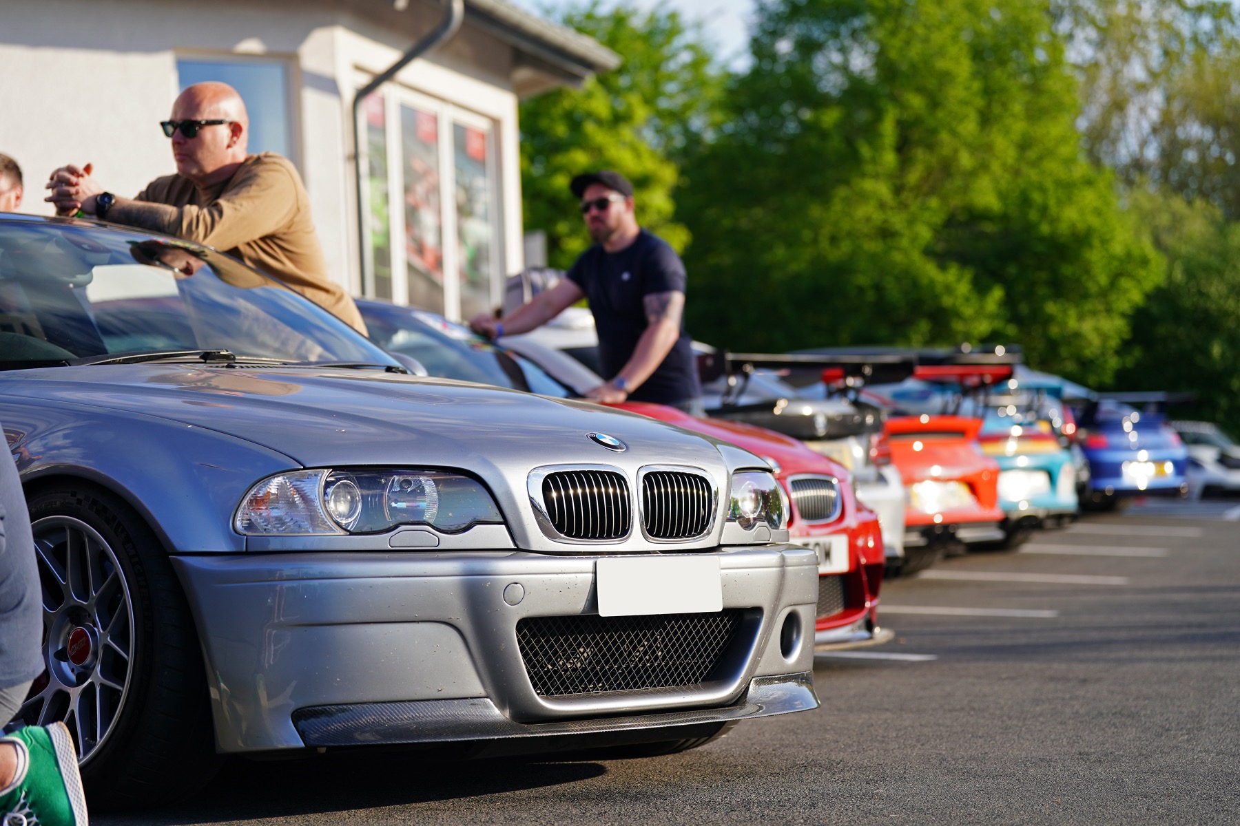 A group of sports cars lined up in the sunshine at the nurburgring